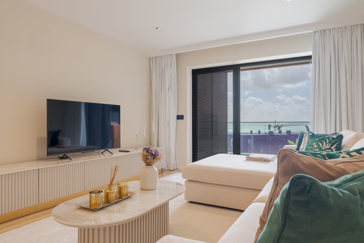 Sala de Estar com mesa de jantar para 4 pessoas, sofá e televisão.