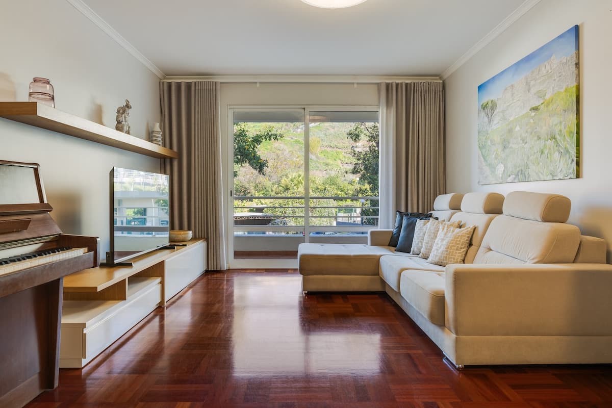 Living room with sofa, television and a piano