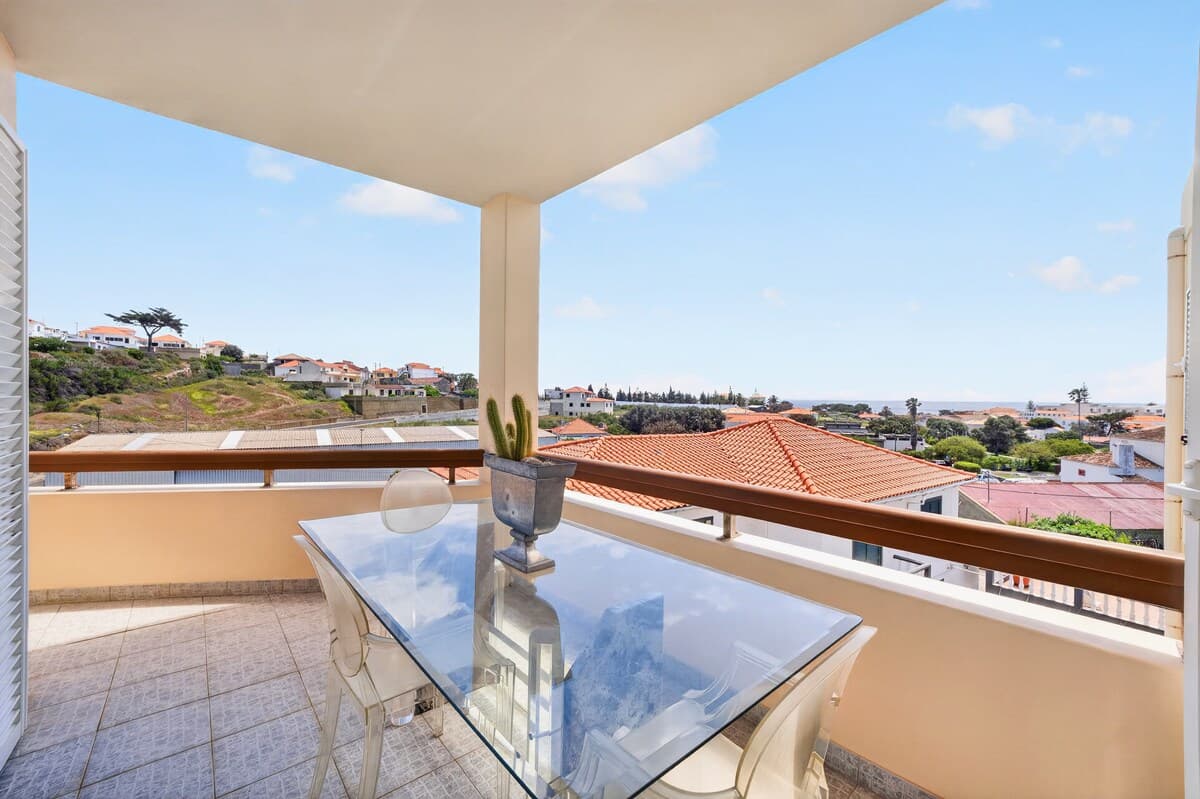 Spacious balcony with outdoor dining area and open views.